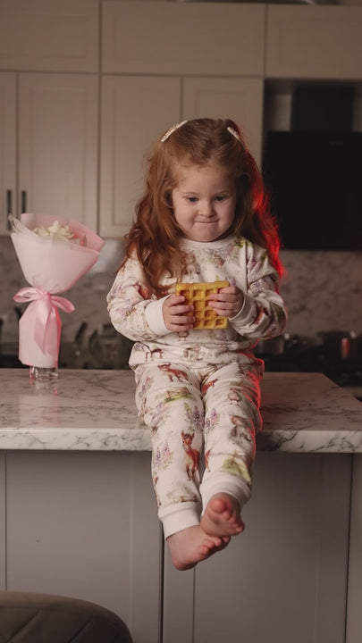 Charming kids pyjamas with a playful cow and curious kitten surrounded by ponies, birds and purple flowers – soft cotton sleepwear inspired by the countryside.